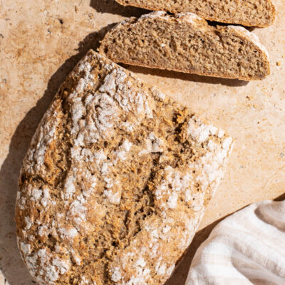 An oval loaf of bread with two slices cut.