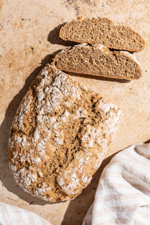 An oval loaf of bread with two slices cut.