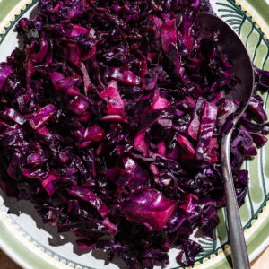 Cooked red cabbage on a plate with a large spoon.