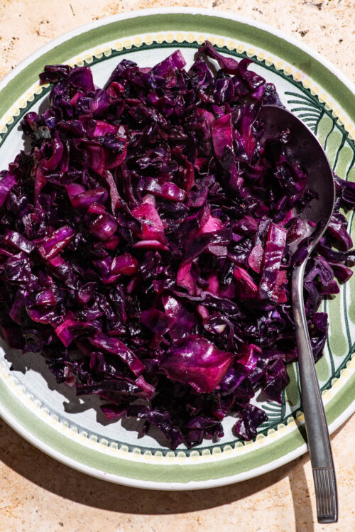 Cooked red cabbage on a plate with a large spoon.