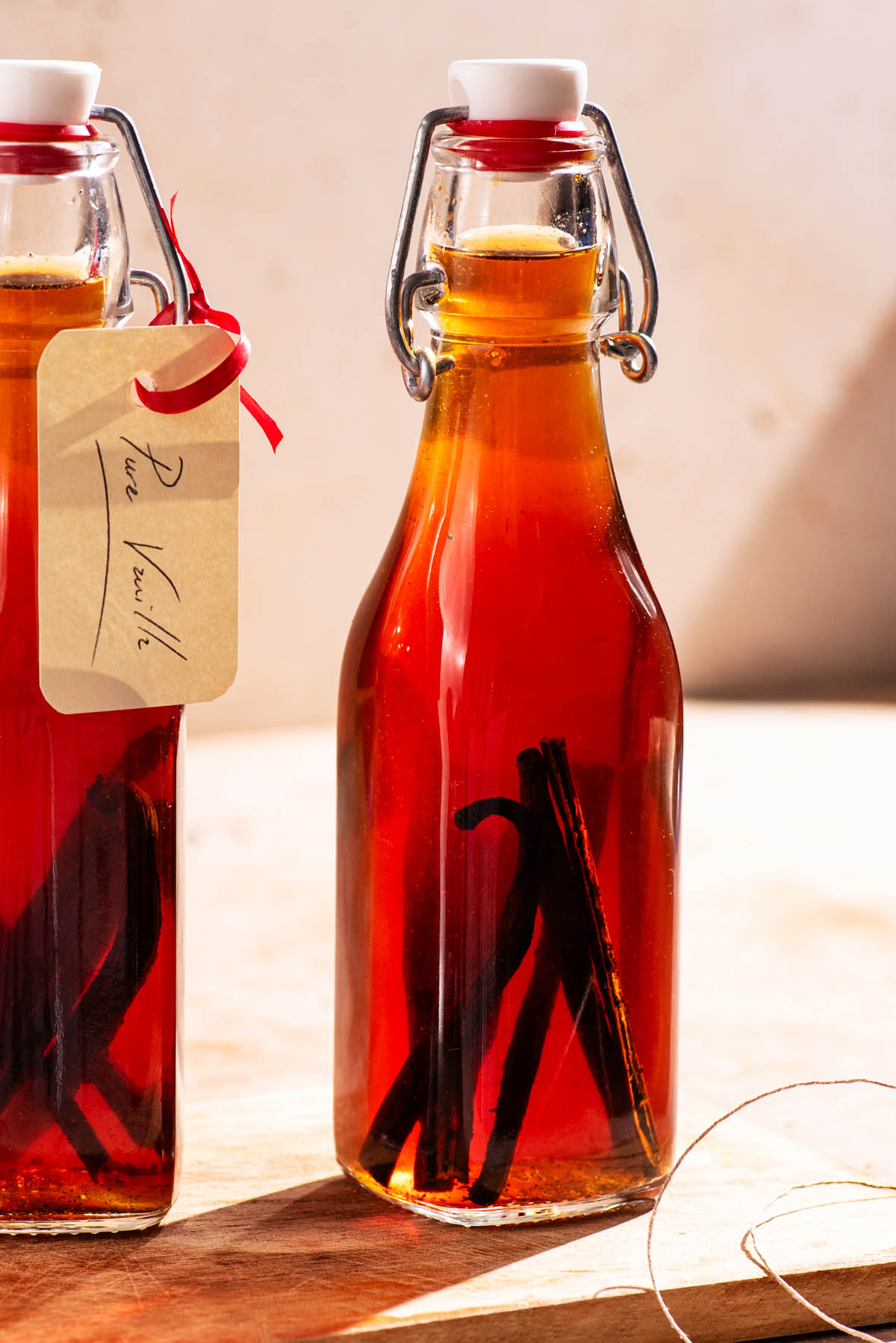 Small glass bottles of vanilla extract with pieces of vanilla beans inside.