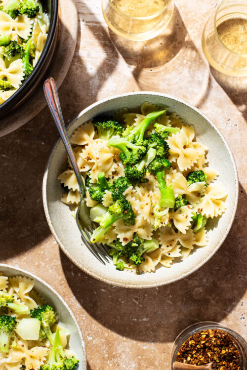 Bowls of farfalle with broccoli.
