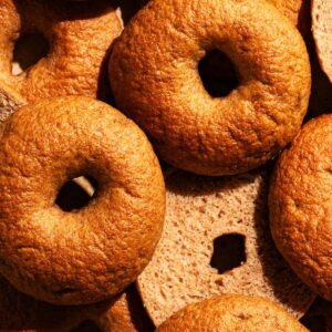 Several golden brown bagels, some halved to show interior texture.