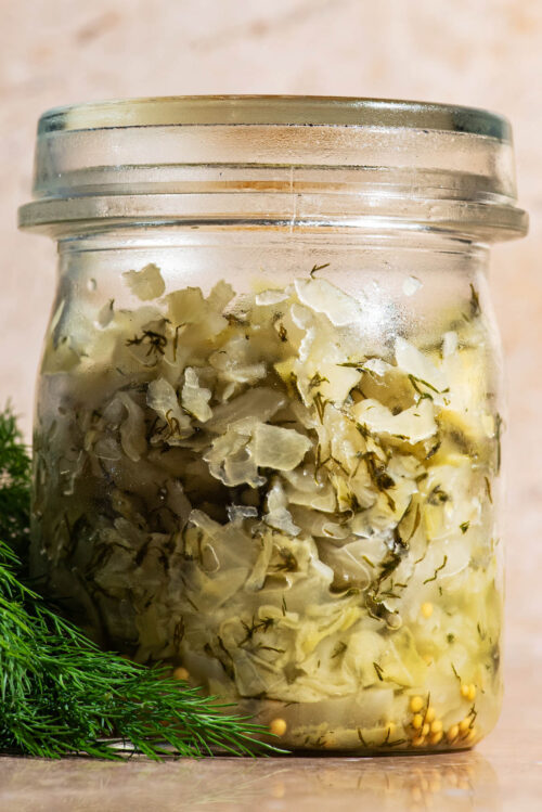Lidded glass jar filled with dill sauerkraut.