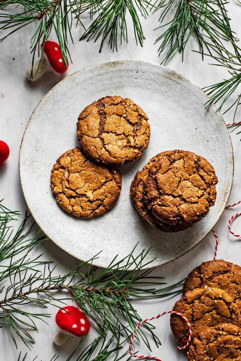 Ginger nuts on a plate with greenery around.