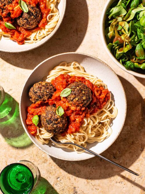 Bean balls with spaghetti and tomato sauce in two bowls.