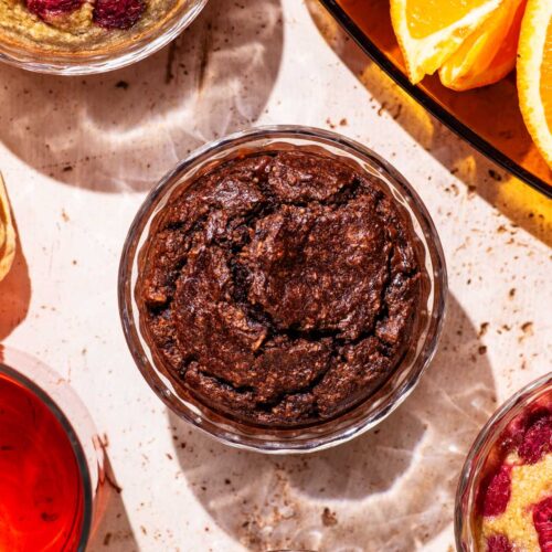 Ramekins with a baked blended oatmeal, with tea and orange slices nearby.