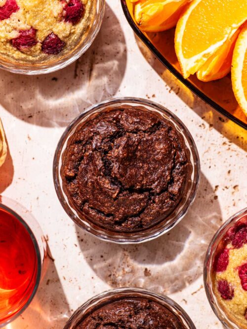 Ramekins with a baked blended oatmeal, with tea and orange slices nearby.