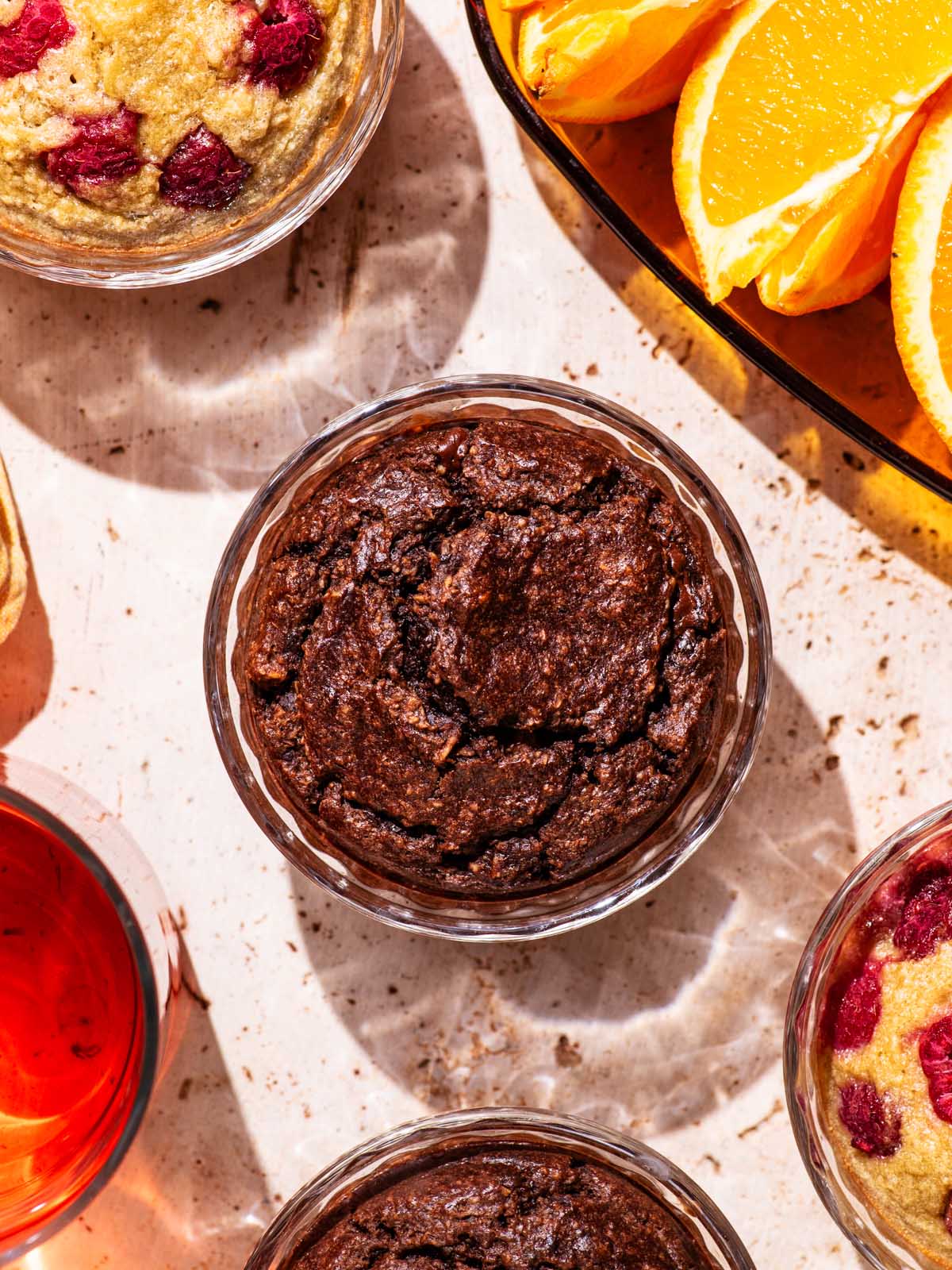 Ramekins with a baked blended oatmeal, with tea and orange slices nearby.