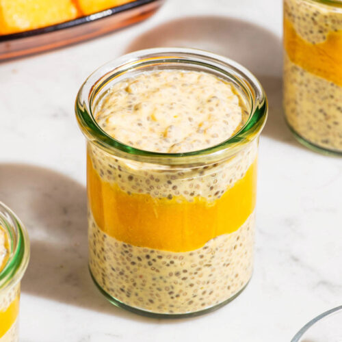 Mango chia seed pudding in small glass jars with mango puree layered in.