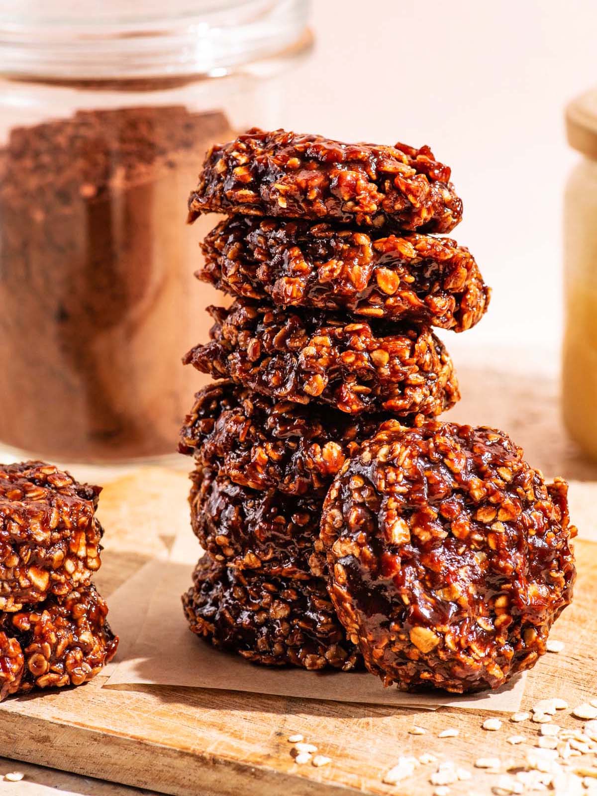 A stack of no-bake chocolate cookies on a small wooden cutting board.