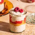 Chia pudding in small glass jars, layered with raspberry jam and peanut butter.