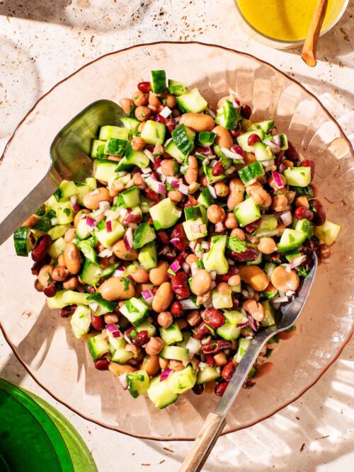 Bean and cucumber salad in a glass serving bowl.
