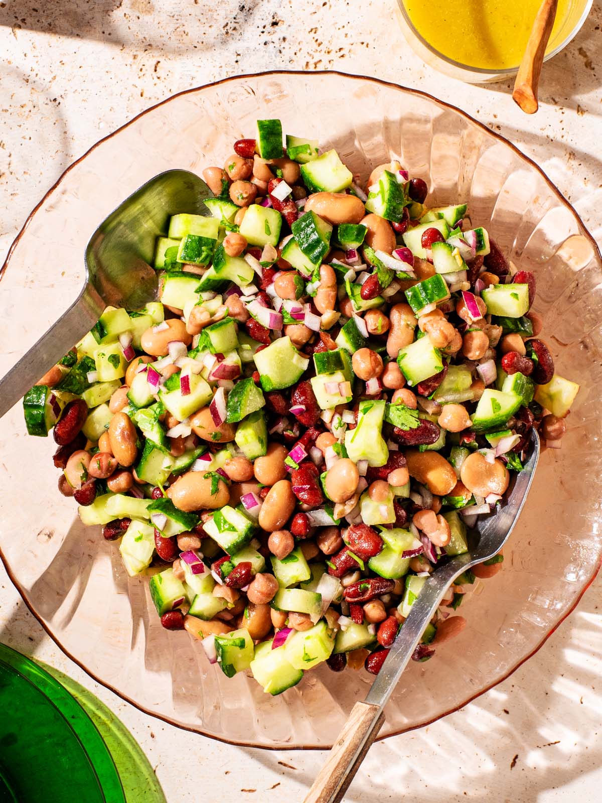 Bean and cucumber salad in a glass serving bowl.