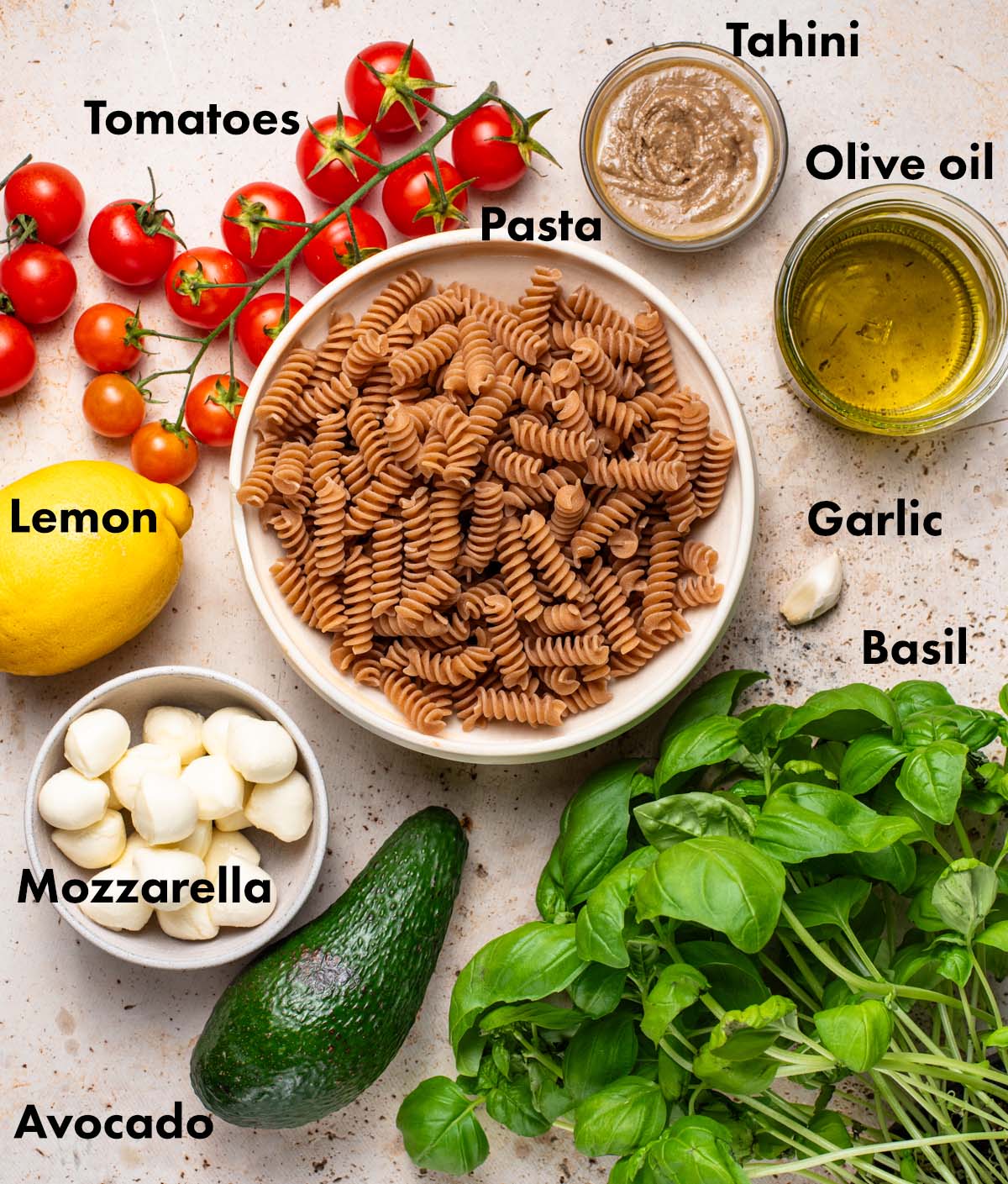 Pesto pasta salad ingredients with labels.