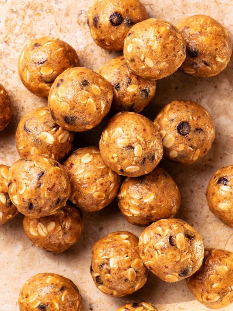 Several energy bites piled together on a stone background.