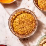 Orange-hued baked oats in small glass ramekins.