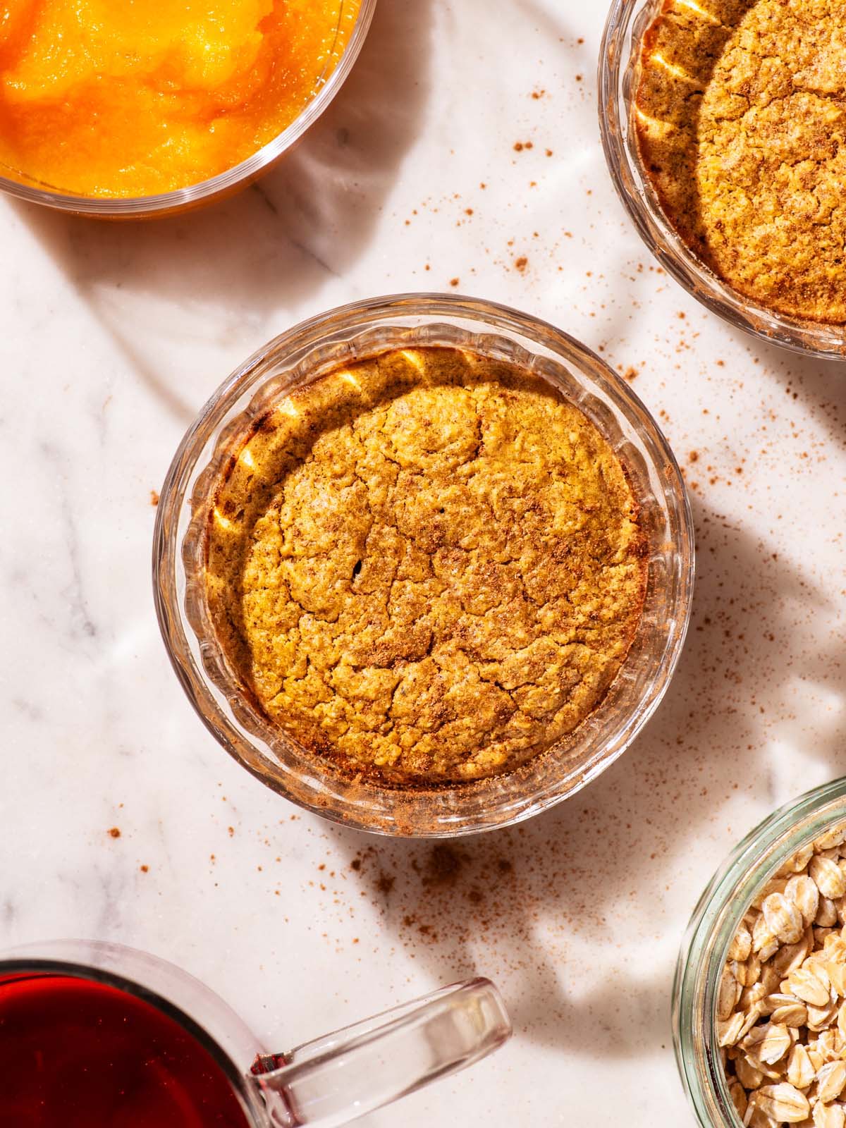 Orange-hued baked oats in small glass ramekins.