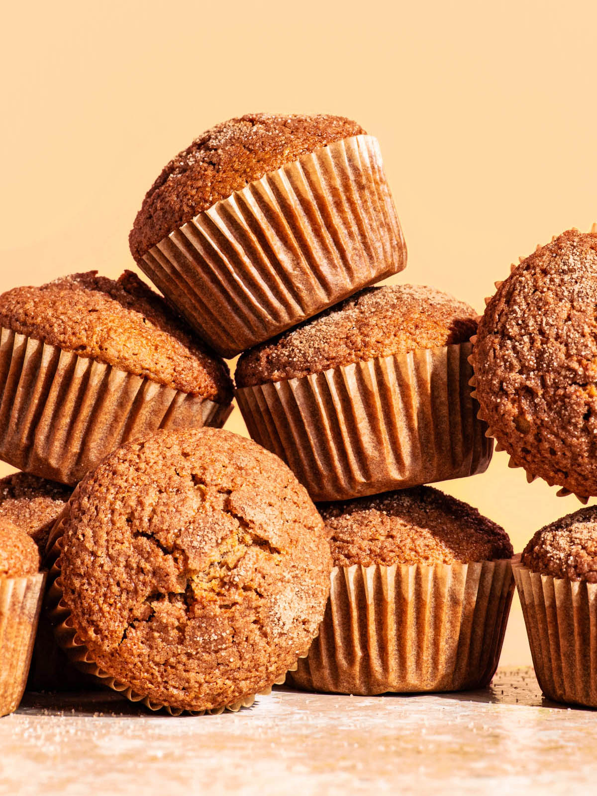 Several plain muffins in paper liners piled up together.