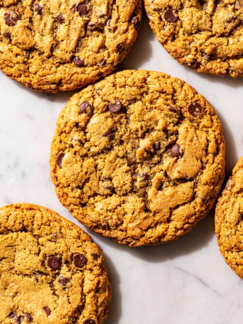Chocolate chip cookies on a marble work surface.