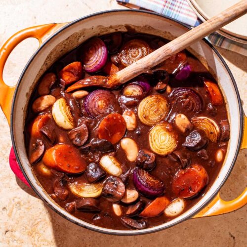 A dark mushroom stew with carrots and onions.